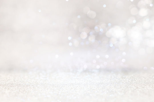 abstract backgrounf of glitter vintage lights . silver and white. de-focused