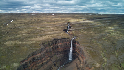 Aerial photography of several waterfalls in Iceland where the different tectonic layers are seen.
