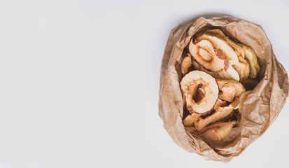 panorama of tasty dried apples chips in paper bag, banner