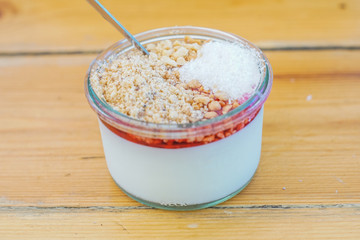   "Malabi" on a wooden table - "Malabi" is  the Israeli ultimate dessert ! milk pudding that served with rose water and sugar syrup , nuts and grounded coconut. 