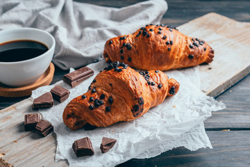 chocolate croissants with coffee on wooden table