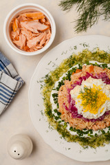 Traditional Russian Mimosa salad with salmon cheese and potatoes. Top view