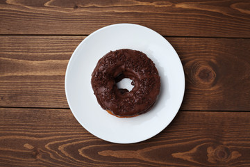お皿にのせた チョコレート ドーナッツ 木のテーブル