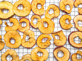 organic dried apple chips on metal tray on white background