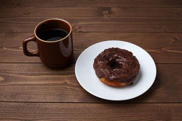 お皿にのせた チョコレート ドーナッツ とホットコーヒー 木のテーブル