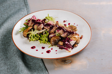 Dish with duck meat with sauce and spices on the wooden background