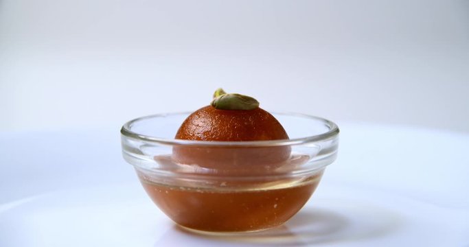 Gulab jamun (indian sweet) on white background with toppings