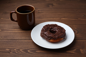 お皿にのせた チョコレート ドーナッツ とホットコーヒー 木のテーブル