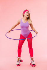 Image of pleased beautiful woman doing exercise with hula hoop