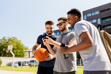 sport, leisure games and male friendship concept - group of men or friends with smartphone at...