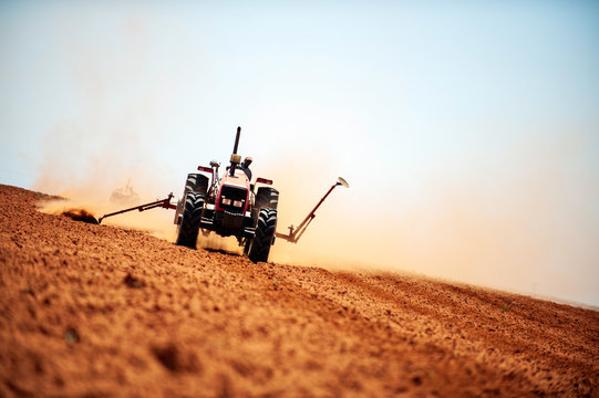 Hot heat summer sun ploughing fields in Kwazulu Natal South Africa, dusty movement blur, tractors, machinery