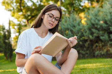 Fototapeta na wymiar Smiling young girl reading a book