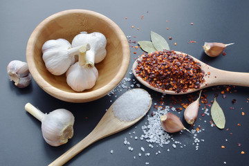 pepper, garlic, bay leaf and sea salt spices on dark background