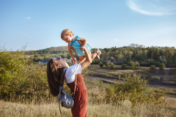 Happy mother and daughter on a green field at sunset.