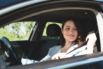 Naklejka premium Woman fastening seat belt on drivers seat