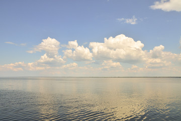 Photo of the boundless sea, which reflects the clouds.