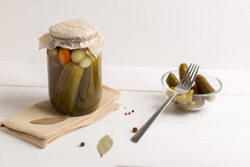 glass jar with pickled cucumbers on white background