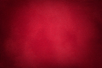 Dark red matte background of suede fabric, closeup.