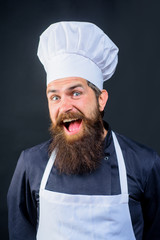 Chef ready to cook new dish. Bearded man in chef uniform. Male chef, cook or baker in white hat and apron. Professional happy man chef. Cooking, profession, business.Professional approach to business.