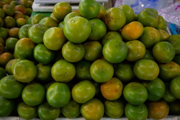 heap of orange fruits in market .