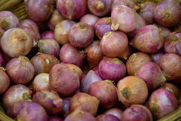 heap of onions vegetable in market .