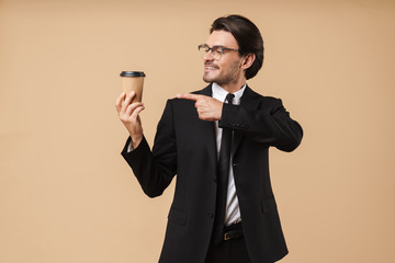 Image of confident businessman smiling and holding takeaway coffee cup