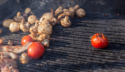 Obraz premium Tomato and mushrooms with meat grilled on a large grill