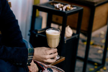 Fall hot punch cocktail in a man's hand. Autumn winter warming drink. Drink photography concept. Close up