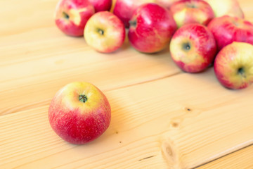 Red apples on wooden light background. Autumn harvest.  Selective focus. 