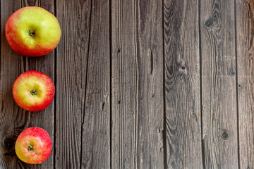 Red apples on wooden dark background. Autumn harvest.   Flat lay.  Copy space.