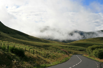 road, prairies and mountains in auvergne (france) 