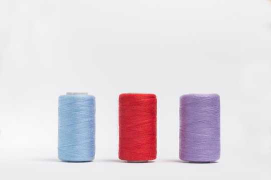 three skeins of multi-colored threads on a white background