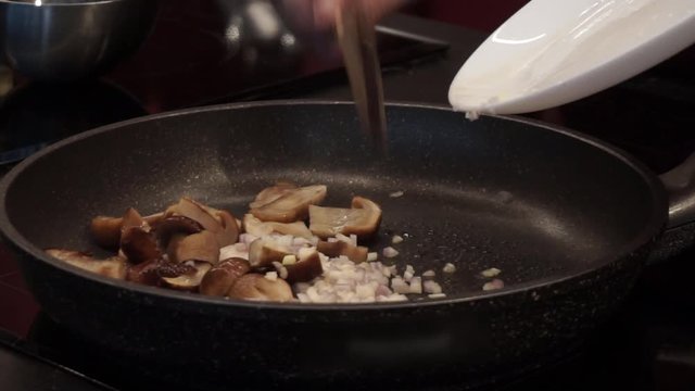 Frying mushrooms with garlic and onion. Cooking pasta. Italian cuisine