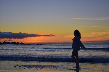 Fototapeta na wymiar funny girl at sunset on the beach