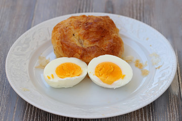 Boyoz and eggs cut in half in white plate.