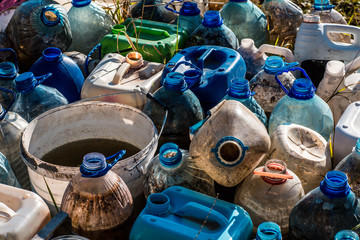 Plastic waste dumping site. Plastick garbage bottles and buckets