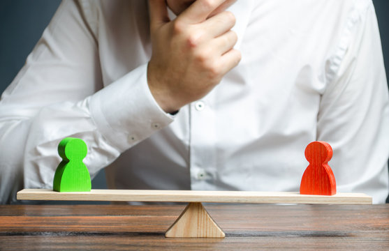 Man holds his hand on chin looks at the discussion process between red and green figures on a scales. Weighted decision. conflict resolution and the search for a compromise in the dispute.