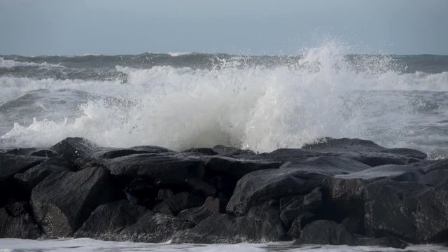 Waves rolling on the beach is a stormy day, winter mediterranean sea. Focene, Lazio, Italy. Slow motion