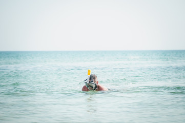 Man swimming with snorkeling mask in the ocean