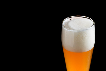A glass of wheat beer on a dark background close-up with copyspace