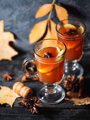 Two glasses of grog alcoholic drink or mulled wine on a dark table