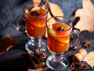 Two glasses of grog alcoholic drink or mulled wine on a dark table