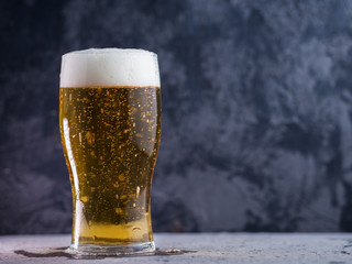 a glass of lager on the table with copyspace
