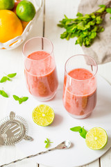Two Glasses of Smoothie with Berries, Grapefruit, Lemon, Lime and Mint on White Wooden Background, Detox Time