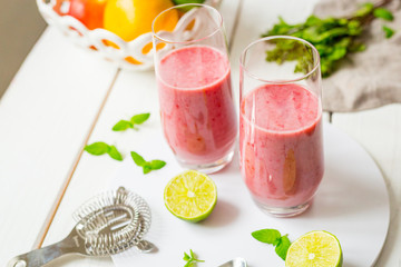 Two Glasses of Smoothie with Berries, Grapefruit, Lemon, Lime and Mint on White Wooden Background, Detox Time