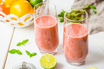 Two Glasses of Smoothie with Berries, Grapefruit, Lemon, Lime and Mint on White Wooden Background, Detox Time