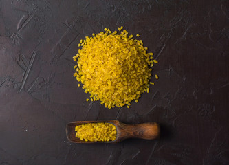 Bulgur lying in a heap on a dark background. Useful organic food for breakfast or diet. Plenty of...