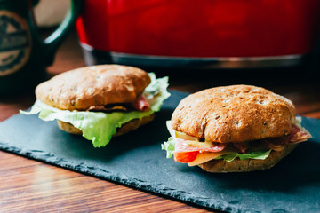 Toasts with Salami or Ham, Cheese, Pickles, Lettuce and Mustard on the Black Stone Board