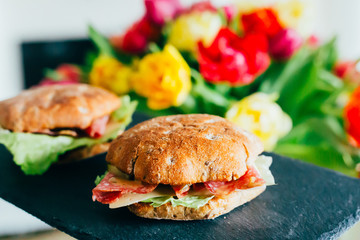 Toasts with Salami or Ham, Cheese, Pickles, Lettuce and Mustard on the Black Stone Board