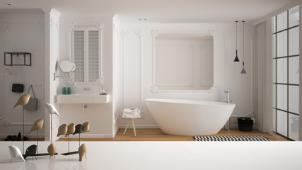 White table top or shelf with minimalistic bird ornament, birdie knick - knack over blurred contemporary white bathroom with bathtub, sink, carpet and window, modern interior design